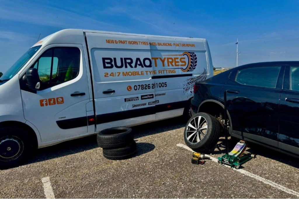 Buraq Tyres mobile fitting van beside black car with wheel off, Bolton